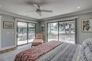 A bedroom with a large bed, a ceiling fan, and a view of the outdoors through a sliding glass door. - New Listing! Luxury Updated 4 BR 3 BA Golf View Near the Beach Pool Sea Pines (Hilton Head Island)