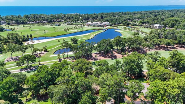 A golf course with a large pond, surrounded by trees and buildings. - New Listing! Luxury Updated 4 BR 3 BA Golf View Near the Beach Pool Sea Pines (Hilton Head Island)