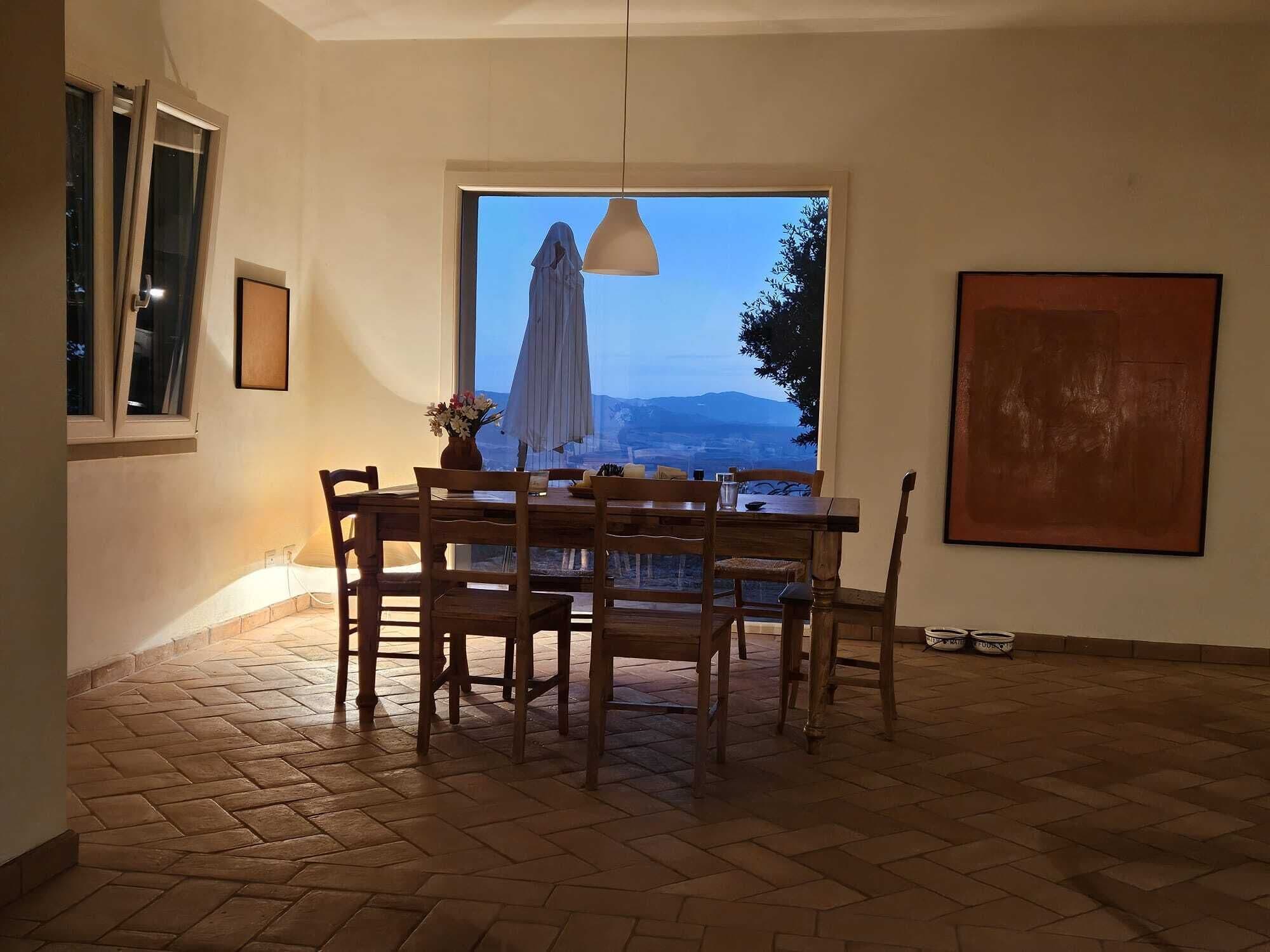 Un'area ristorazione con tavolo e sedie, una finestra vista e un lampadario.