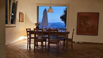 Un'area ristorazione con tavolo e sedie, una finestra vista e un lampadario.