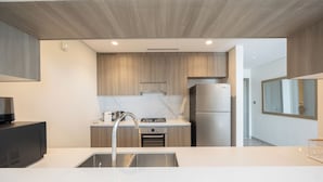 A modern kitchen with a stainless steel sink, a built-in oven, and a refrigerator. - Bloomfields 2BR plus Maid in Yas Golf  (Abu Dhabi)