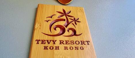 A wooden sign with the text 'TEVY RESORT KOH RONG' and the number '04'.