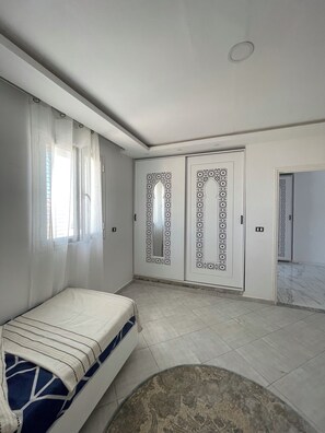 A bedroom with a bed, a wardrobe, and a door with intricate designs.
