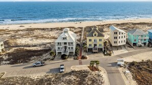 Una zona costiera con spiaggia, una strada e diversi edifici caratterizzati da stili architettonici differenti.