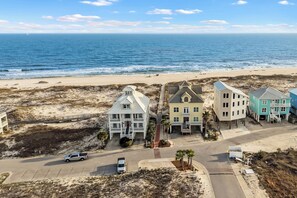 Eine Küstenlandschaft mit Strand, einer Straße und mehreren Gebäuden in unterschiedlichem Baustil.