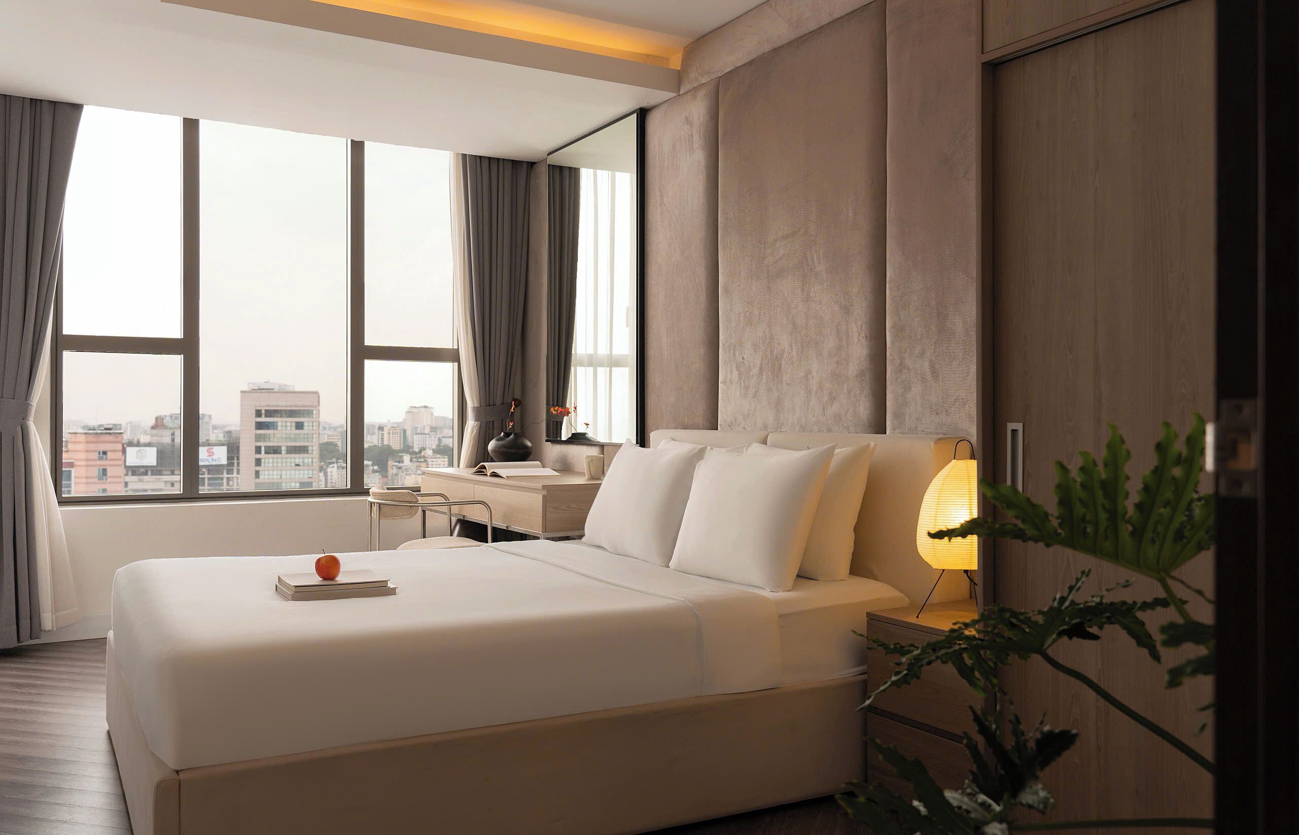Une chambre d’hôtel moderne avec un grand lit, un bureau et une vue sur la ville.