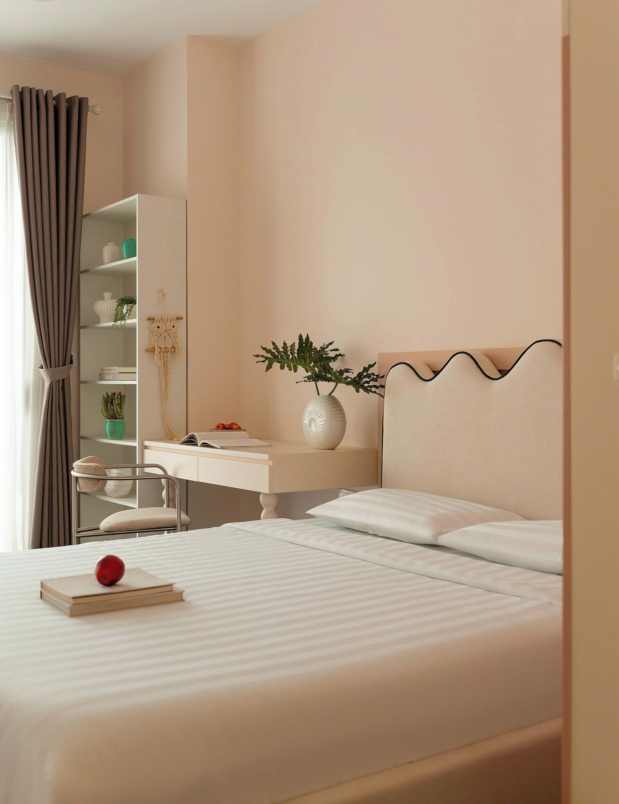 Une chambre d’hôtel bien rangée, avec un lit, un bureau et une chaise.