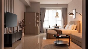 A modern hotel room with a bed, a TV, a sofa, a coffee table, a wardrobe, and a window with curtains. - Maison de Gu Tresor Residence (Ho Chi Minh City)
