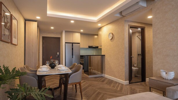 A modern hotel room with a dining area, kitchenette, and a shower. - Maison de Gu Tresor Residence (Ho Chi Minh City)