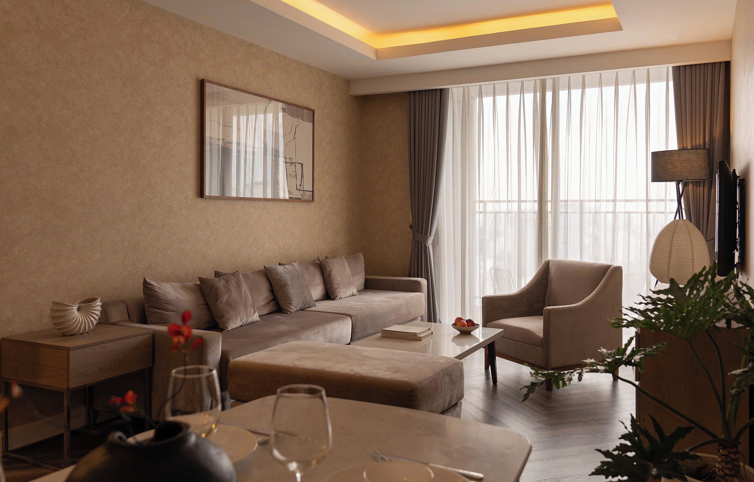 A modern living room with a sectional sofa, a coffee table, and a side table with a vase.