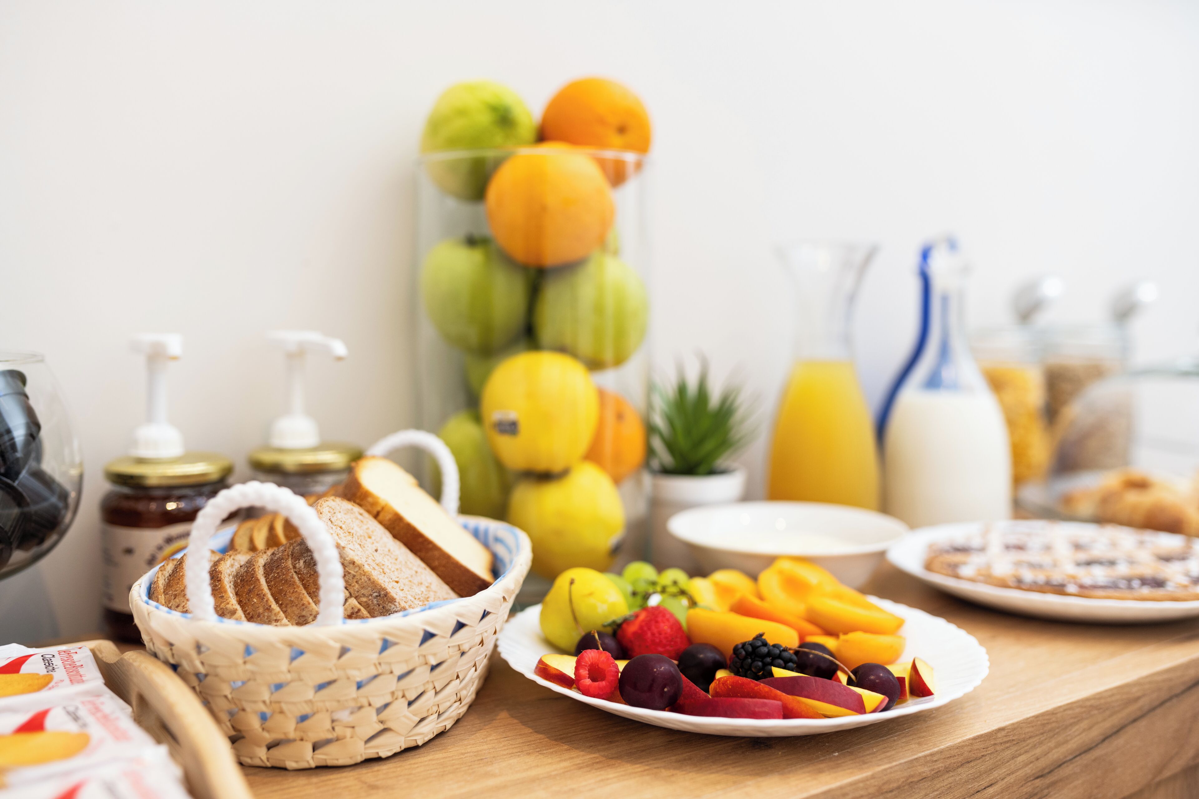 Un bufé de desayuno con diversas frutas, pan y bebidas.