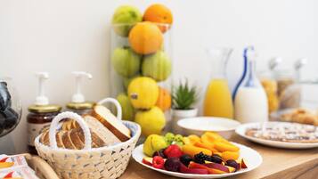 Un bufé de desayuno con diversas frutas, pan y bebidas.