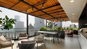 A rooftop terrace with a dining area, seating, and a kitchen. - w Beautifu Cozy 1BR w Balcony in Tabacalera (Mexico City)