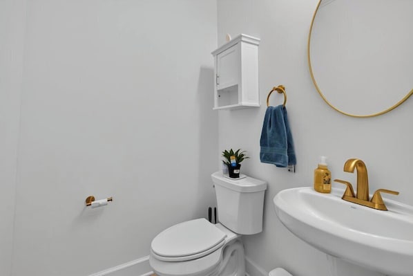 Un bagno con WC, lavandino e mobiletto.