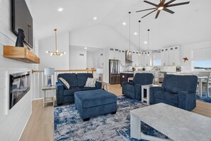 A spacious living area with a sofa set, a coffee table, and a fireplace. - Brand NEW Boaters Dream in Slaughter Beach (Milford)