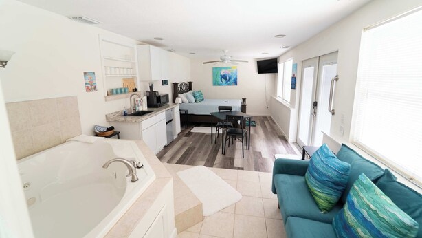 Un interior moderno con cocina, comedor y sala de estar con sofá y un ventanal grande.