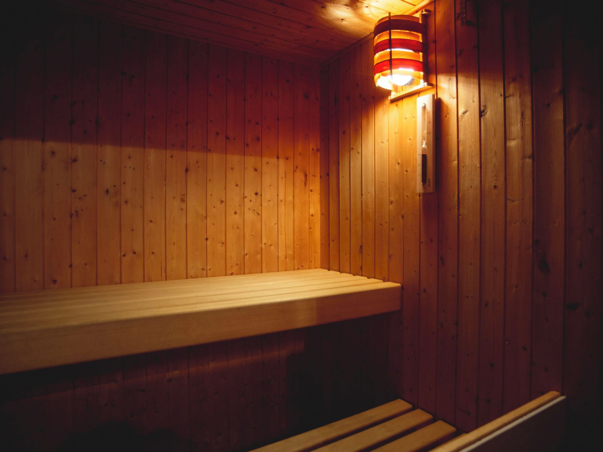 Eine Sauna mit Holzwänden und einer Sitzbank.