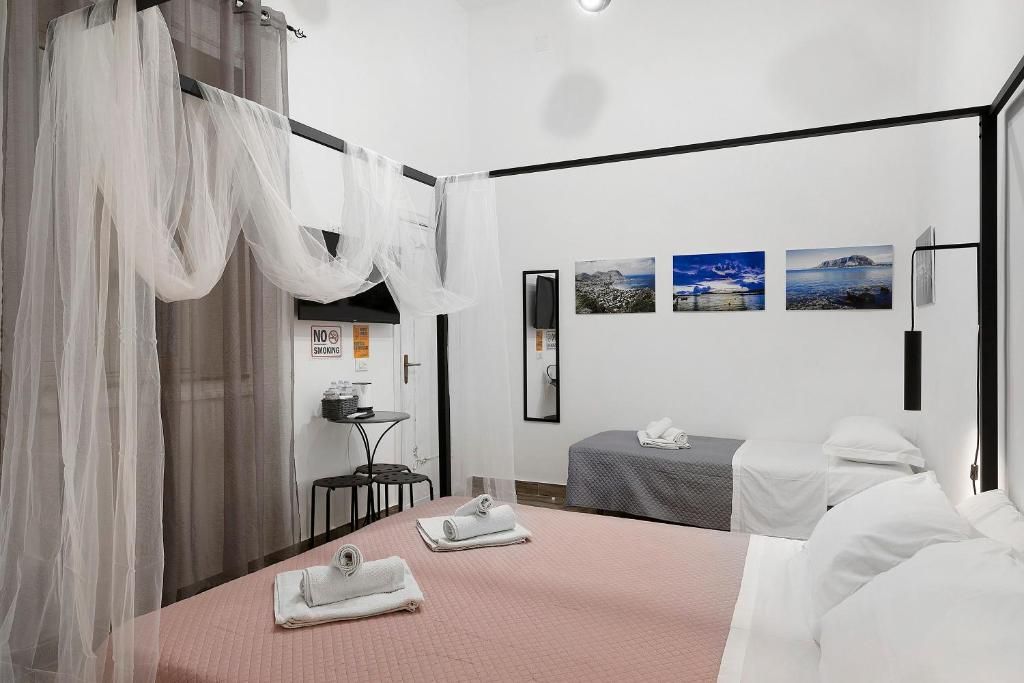 A hotel room with a bed, two bedside tables, a desk, and a chair. There are three framed pictures on the wall.