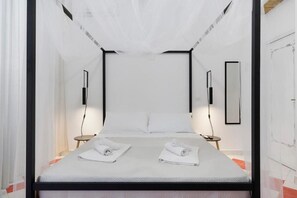 A hotel room with a bed, two bedside tables, and a large window with curtains. - Myla's rooms (Palermo)