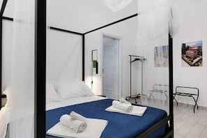 A bedroom with a bed, a bedside table, a chair, and a wardrobe. - Myla's rooms (Palermo)