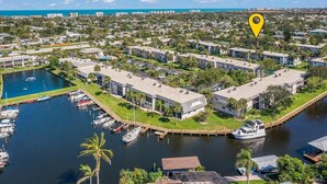A marina with boats, a water body, and a residential area with modern buildings. - Stay Where The Rockets Launch & The Waves Roll In! (Satellite Beach)
