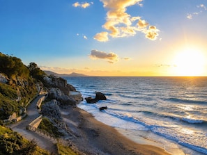 A coastal landscape with a paved path leading to the beach, rocky terrain, and a clear view of the ocean. - Bella Casa Lydia -cozy Stay in the Heart of Rhodes (Rhodes)