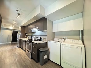 A modern kitchen with a stove, microwave, toaster, and washing machine.