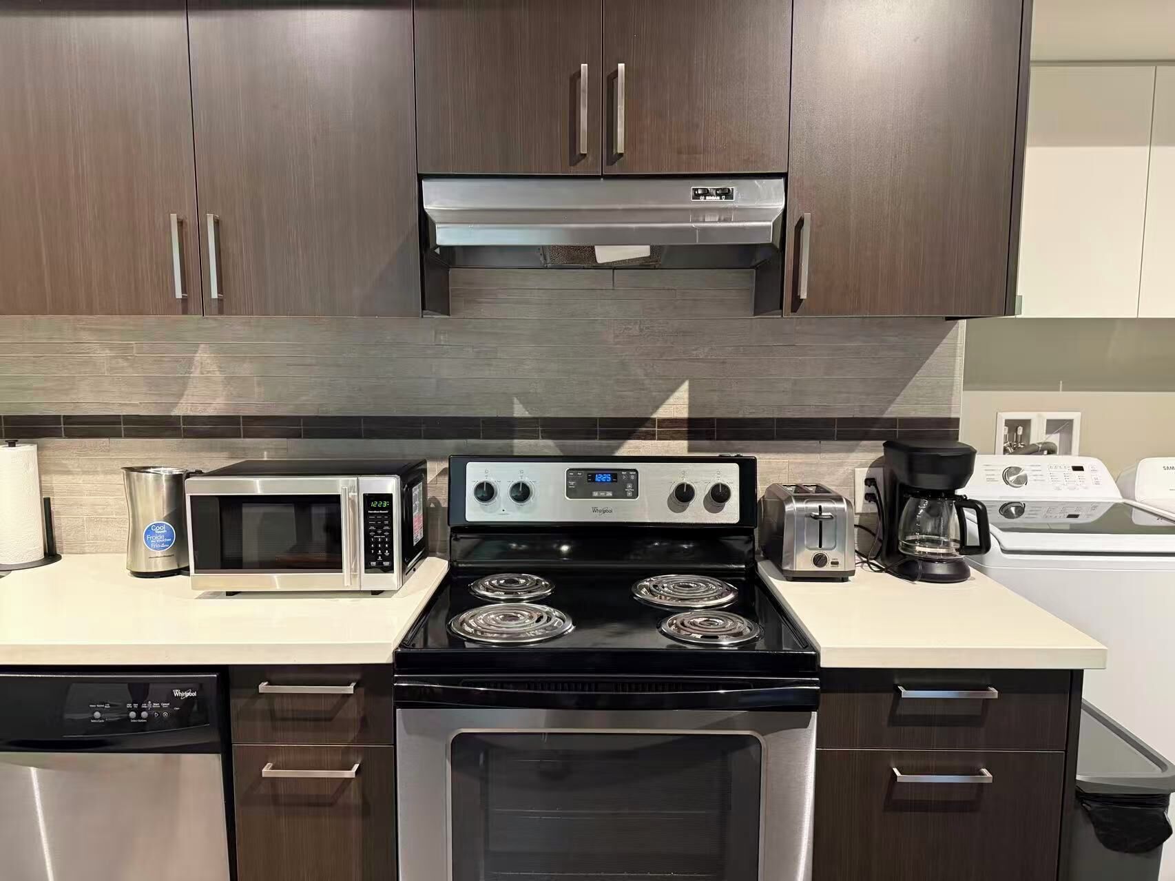A modern kitchen with a built-in microwave, stove, and dishwasher.