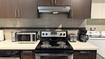 A modern kitchen with a built-in microwave, stove, and dishwasher.