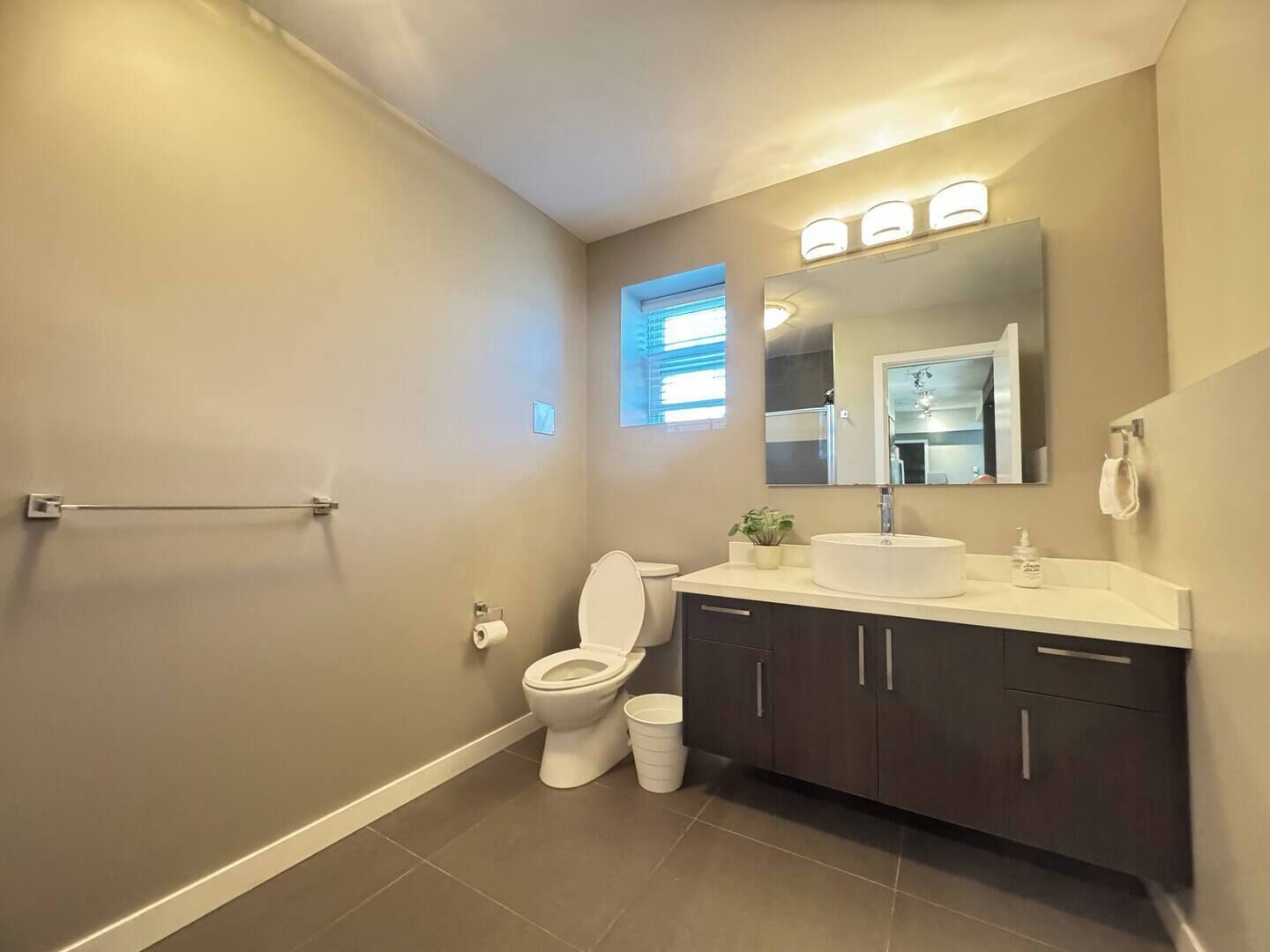 A modern bathroom with a toilet, sink, and mirror.