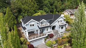 Ein zweistöckiges Haus mit Garage, umgeben von dichtem Grün.
