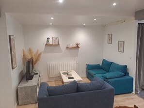 A living room with a sofa, a coffee table, and a radiator. - Accommodation for 6 people (Mareuil-sur-Lay-Dissais)