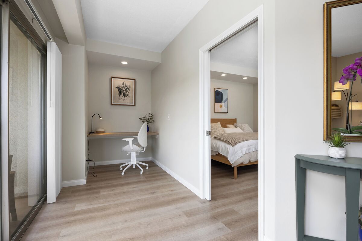 Une chambre à coucher avec un lit, un bureau, une chaise et un miroir.