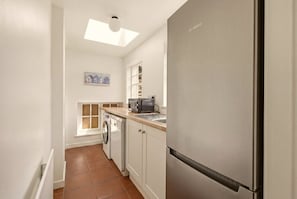 Practical utility room with laundry facilities and additional storage space - Millhouse Cottage - North East Escapes (Waren Mill)