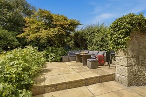 Private stone patio with outdoor seating surrounded by mature cottage gardens - Millhouse Cottage - North East Escapes (Waren Mill)