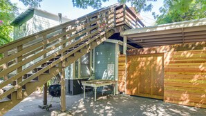 A wooden staircase leading to a garage with a closed wooden door and a 'DRUG FREE ZONE' sign.
