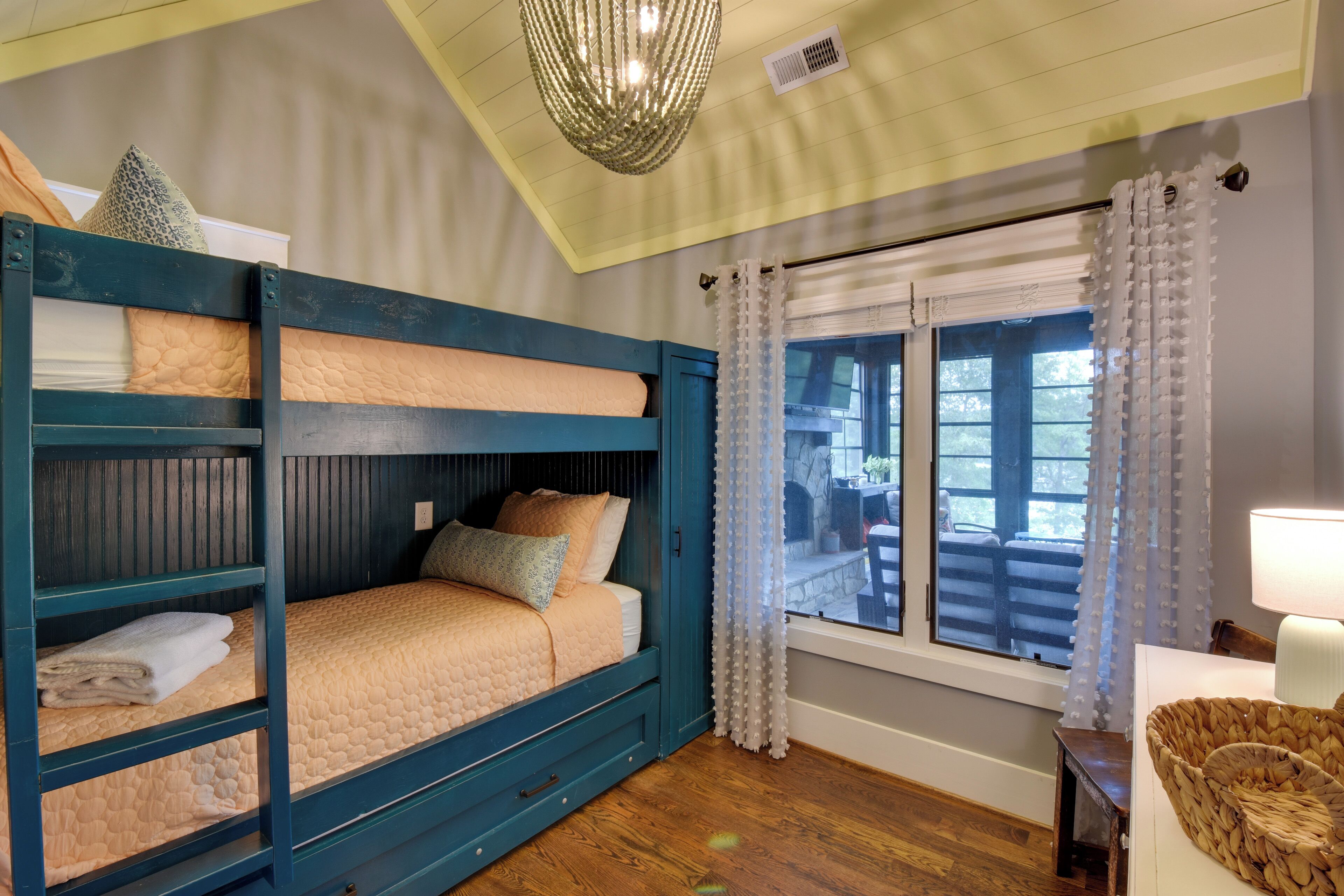 A bunk bed room with a view of the outdoors through a window.