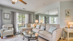 A living room with a sofa, armchairs, a coffee table, and a dining area with a lamp. - Gorgeous Ground Floor Condo Just Steps to Pool! (Calabash)