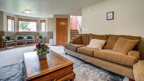 A living room with a brown sofa, wooden coffee table, and green chairs.