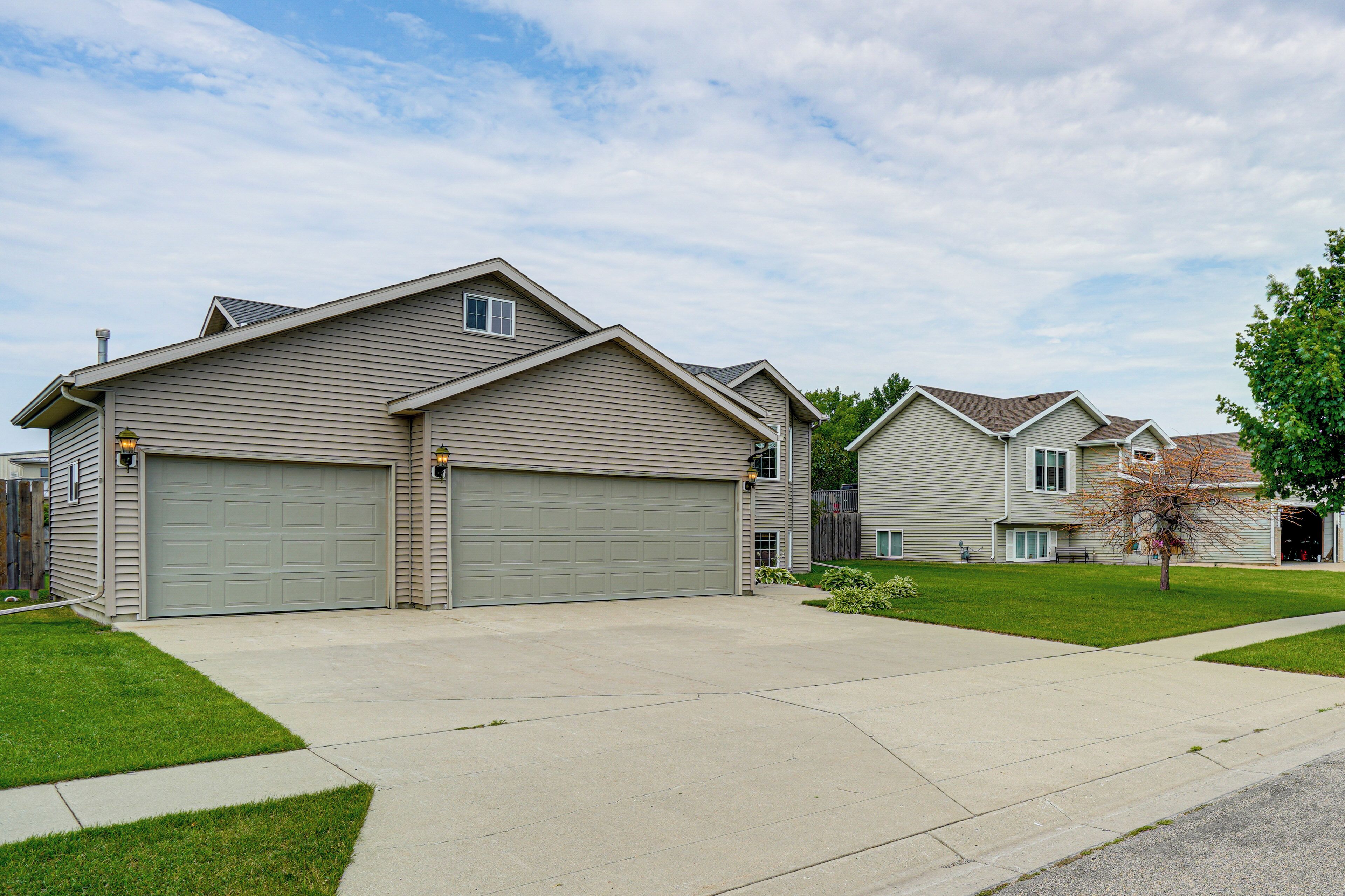A residential area with houses, a driveway, and a lawn.