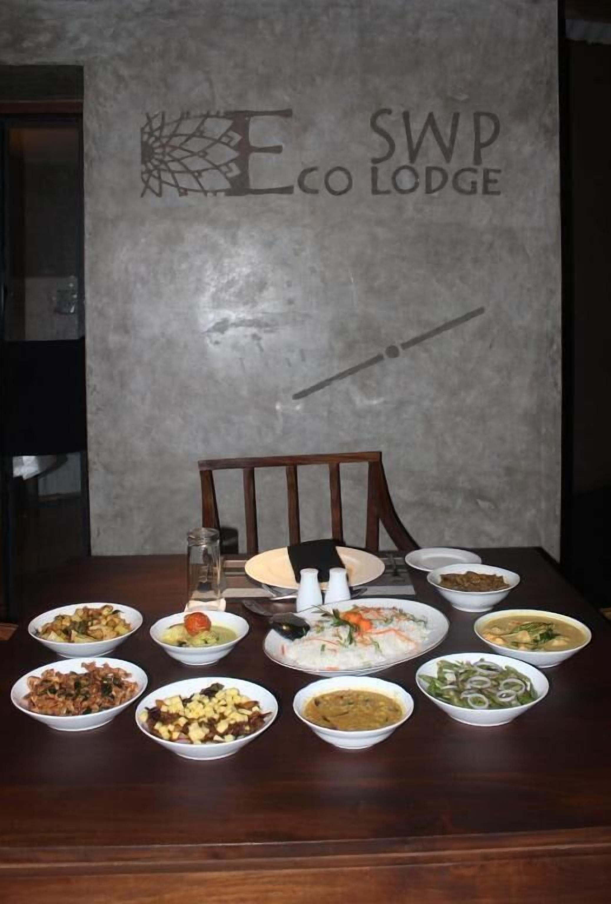 A dining table with various dishes, a chair, and a logo on the wall.