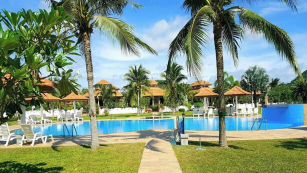 A pool area with lounge chairs, palm trees, and a clear sky. - Premium Long-Stay Villa - Pool, Garden, Near the Beach, 2 Bedrooms, 90 square meters (Hua Hin District)