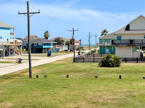 A residential area with houses, a grassy lawn, and a road. - Super Cute 2 bedroom, close to beach, affordable! (Crystal Beach)
