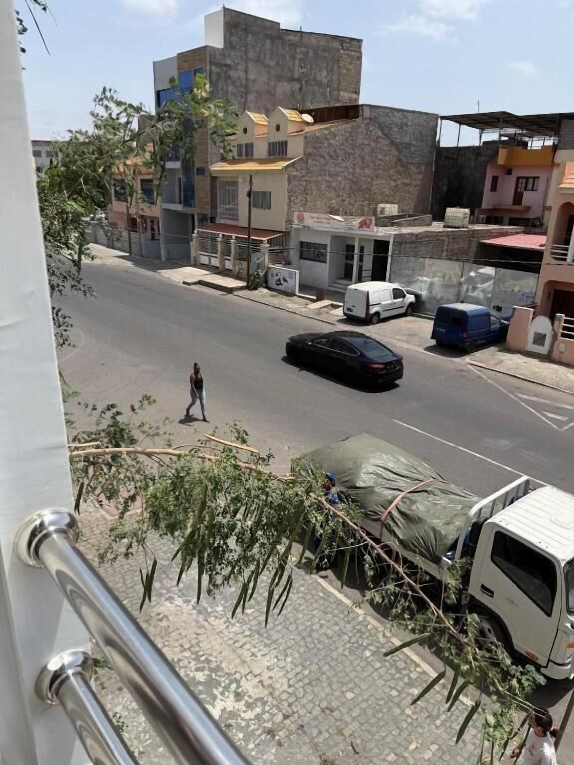 A street view with buildings, a parked van, and a person walking.