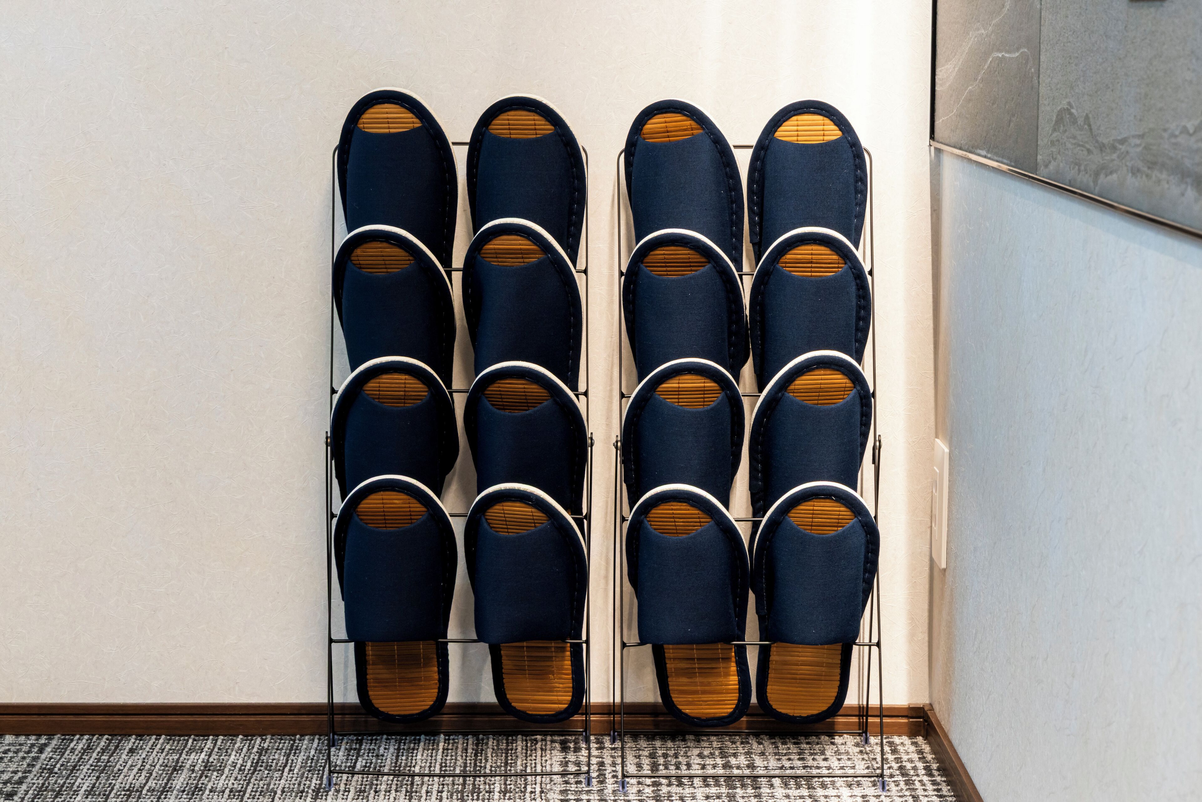 A wall-mounted shoe rack with multiple pairs of shoes.