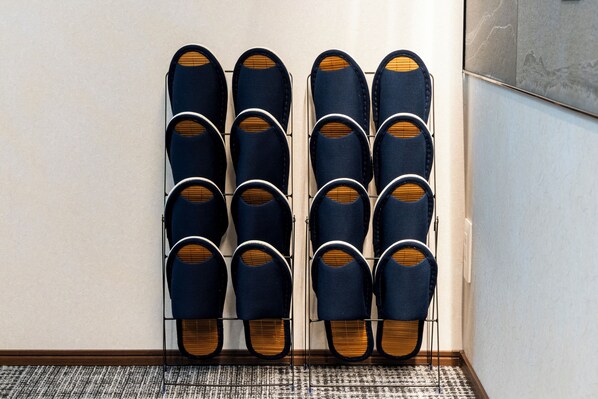 A wall-mounted shoe rack with multiple pairs of shoes. - Asobiyado Rin (Kagoshima-shi)