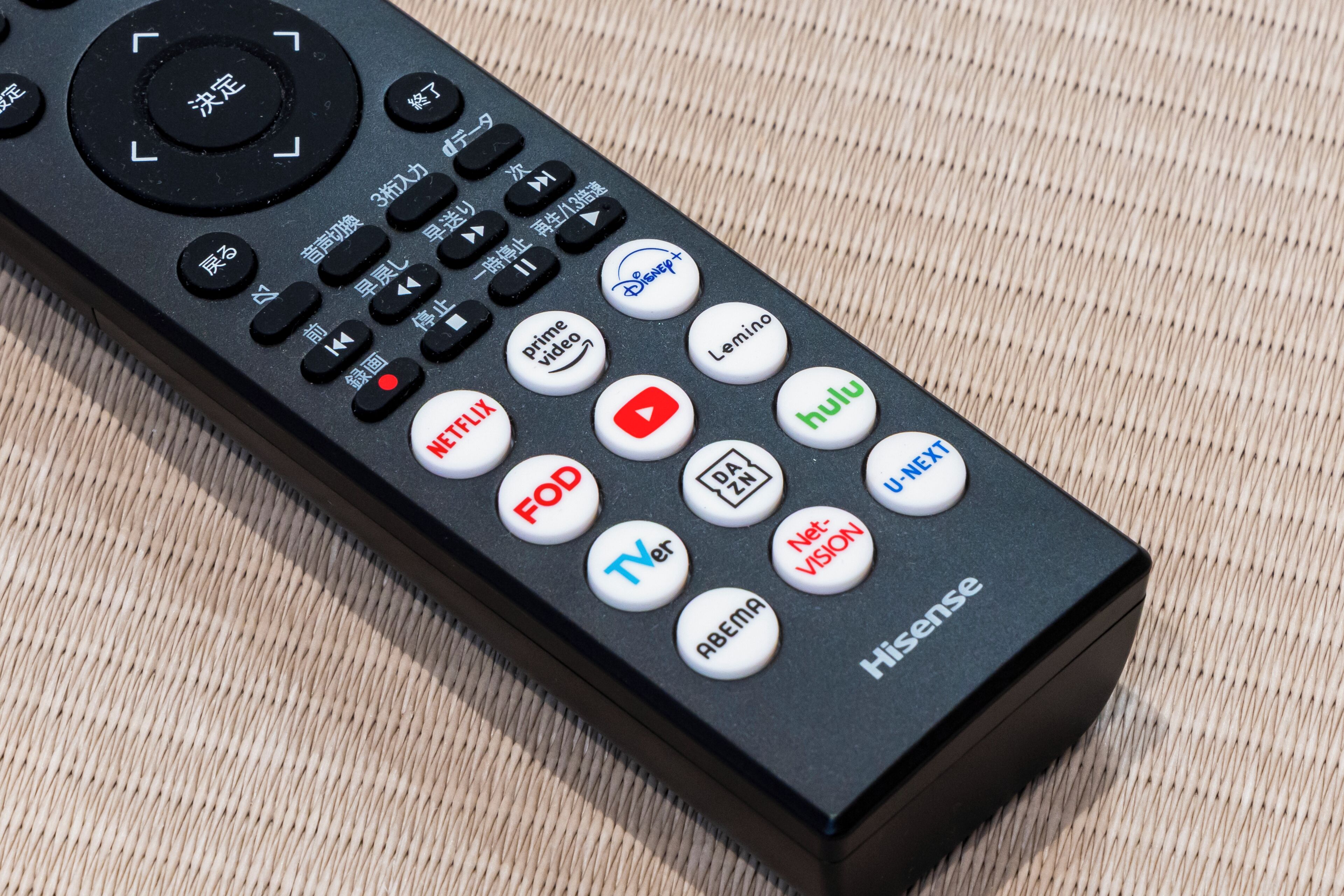 A remote control with multiple buttons, including brand logos like Netflix, Hulu, and Amazon Prime Video.