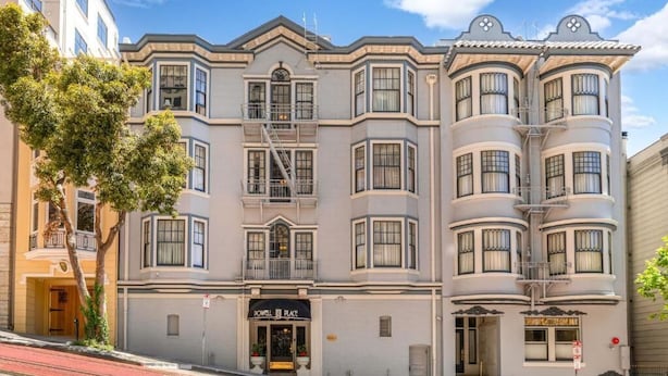 Un edificio a più piani con uno stile architettonico classico, caratterizzato da balconi a bovindo e un ingresso imponente con un cartello che riporta la scritta 