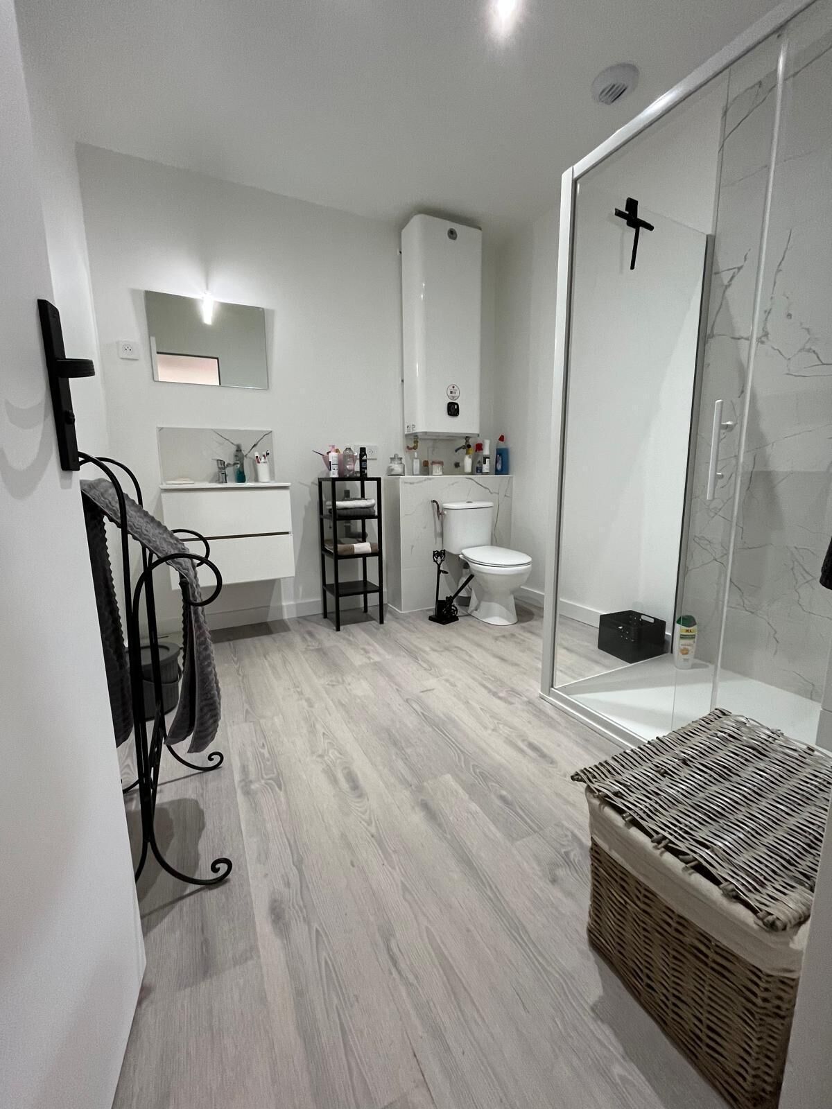 A modern bathroom with a shower, toilet, and sink.