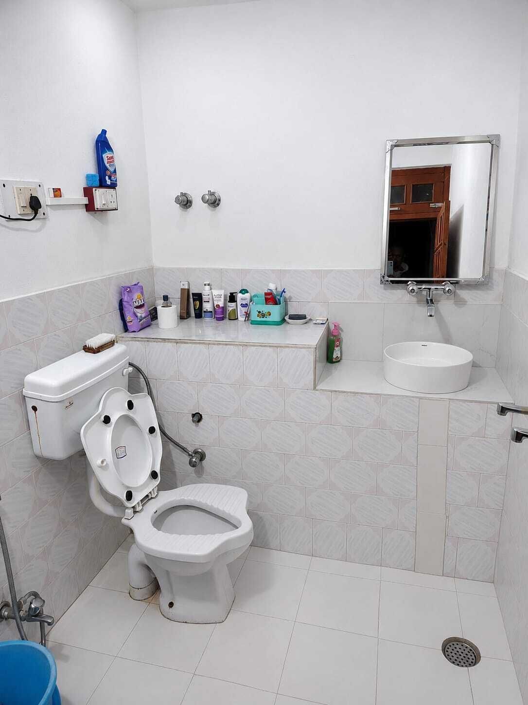 Une salle de bain équipée de toilettes, d’un bidet, d’un lavabo et d’un miroir.